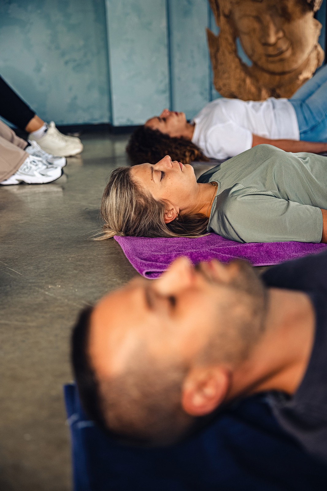 Mensen liggen met hun ogen dicht op een mat tijdens een workshop