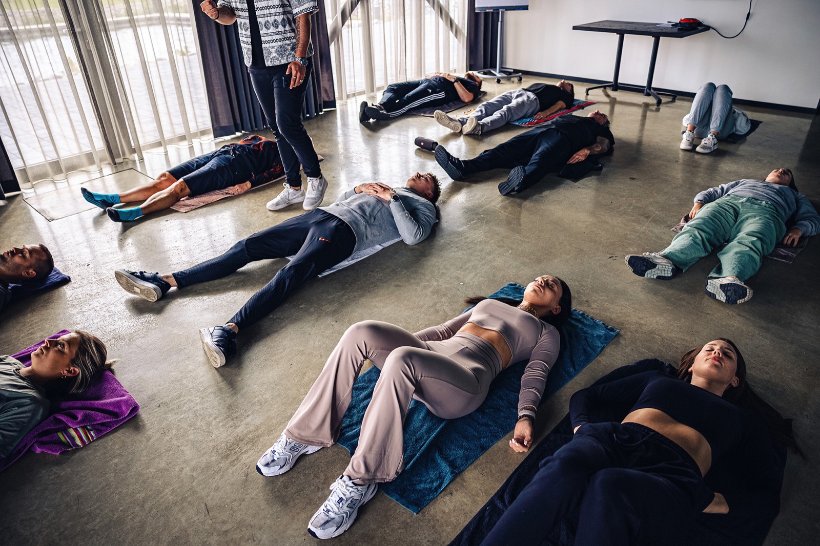 Een groep ligt op matten tijdens een ademsessie